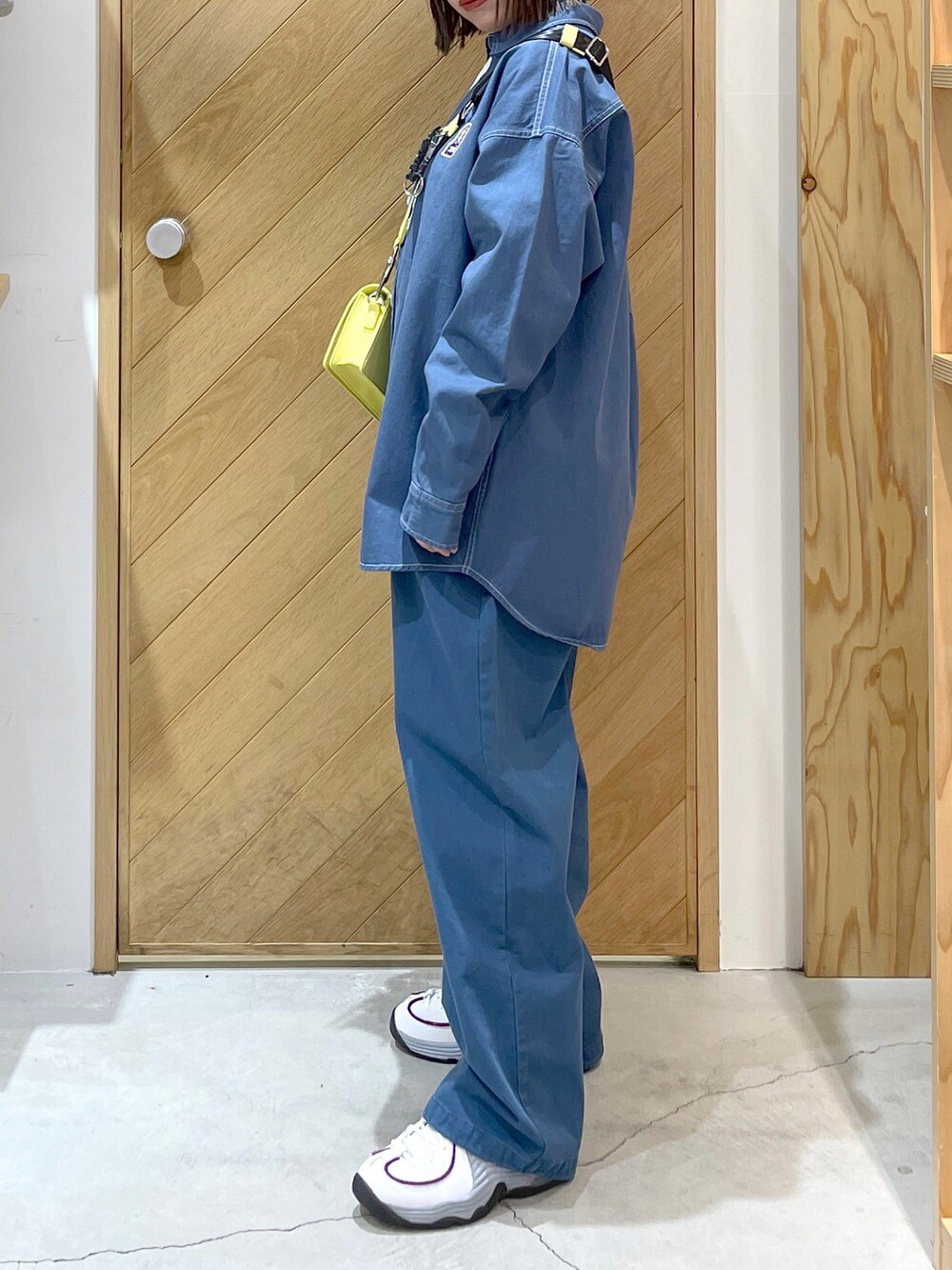 ホワイト系のスニーカー、ブルー系のその他パンツ、イエロー系のショルダーバッグを着用したレディースの春コーディネートの2枚目の写真