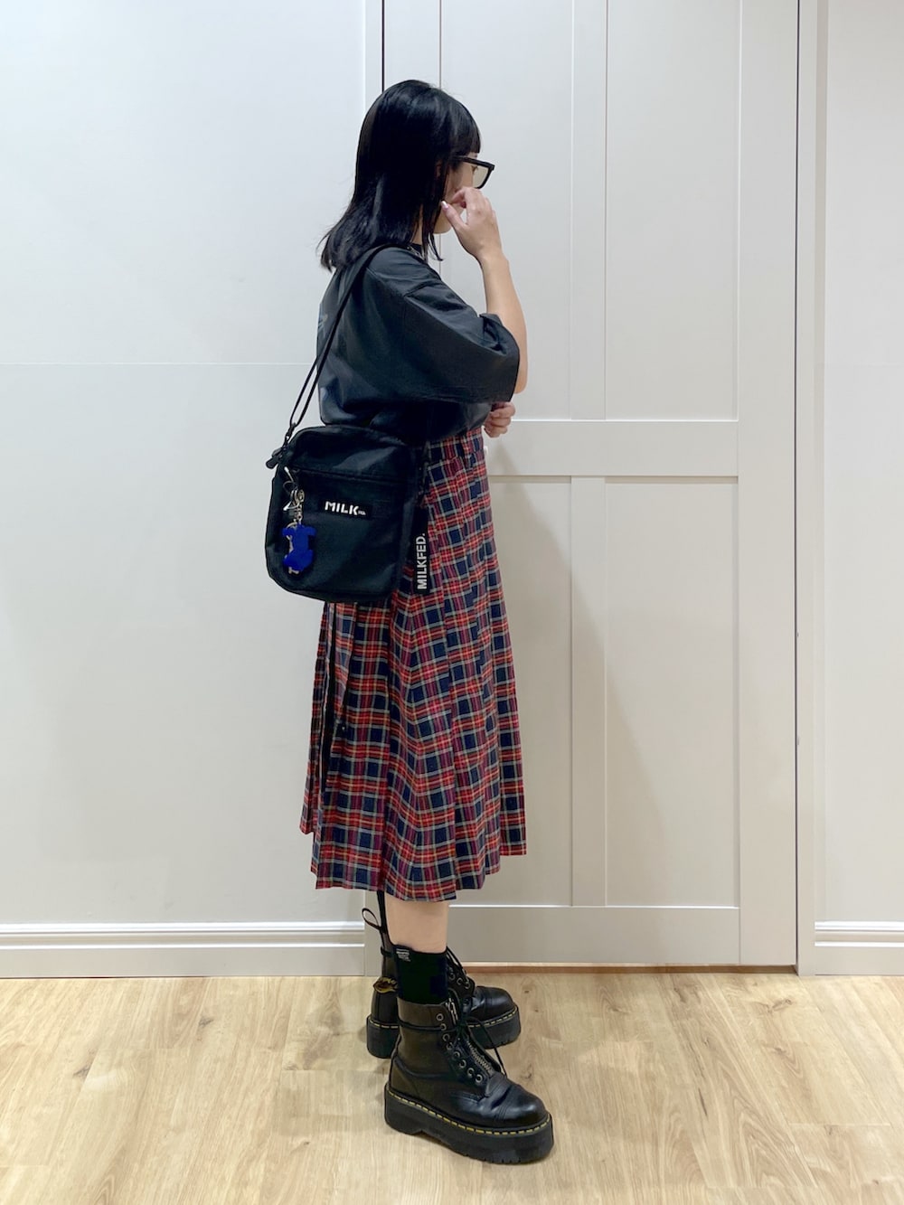 ブラック系のブーツ、ブルー系のスカート、グレー系のTシャツ/カットソーを着用したレディースの夏コーディネートの3枚目の写真