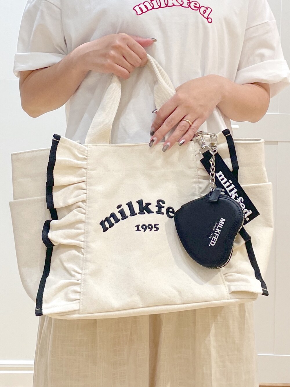 ホワイト系のショルダーバッグ、ホワイト系のTシャツ/カットソー、ホワイト系のワンピースを着用したレディースの春コーディネートの3枚目の写真