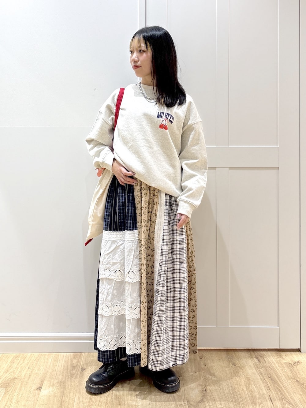 ホワイト系のトートバッグ、ベージュ系のスウェット、ベージュ系のスカートを着用したレディースの冬コーディネートの3枚目の写真