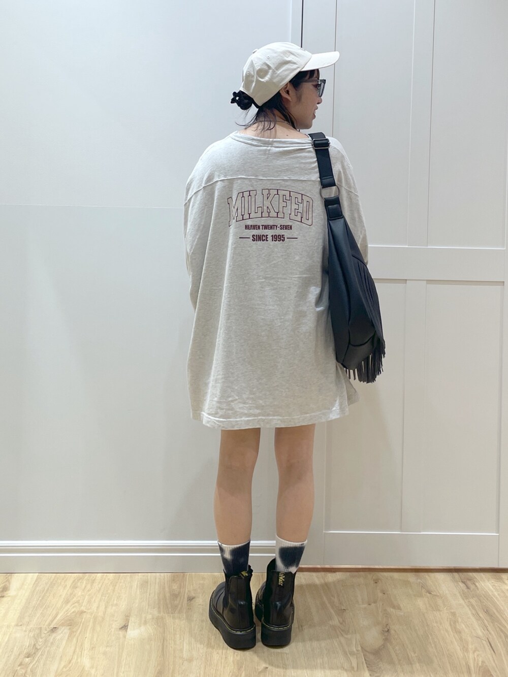 ブラック系のブーツ、ブラック系のショルダーバッグ、ベージュ系のTシャツ/カットソーを着用したレディースの春コーディネートの3枚目の写真