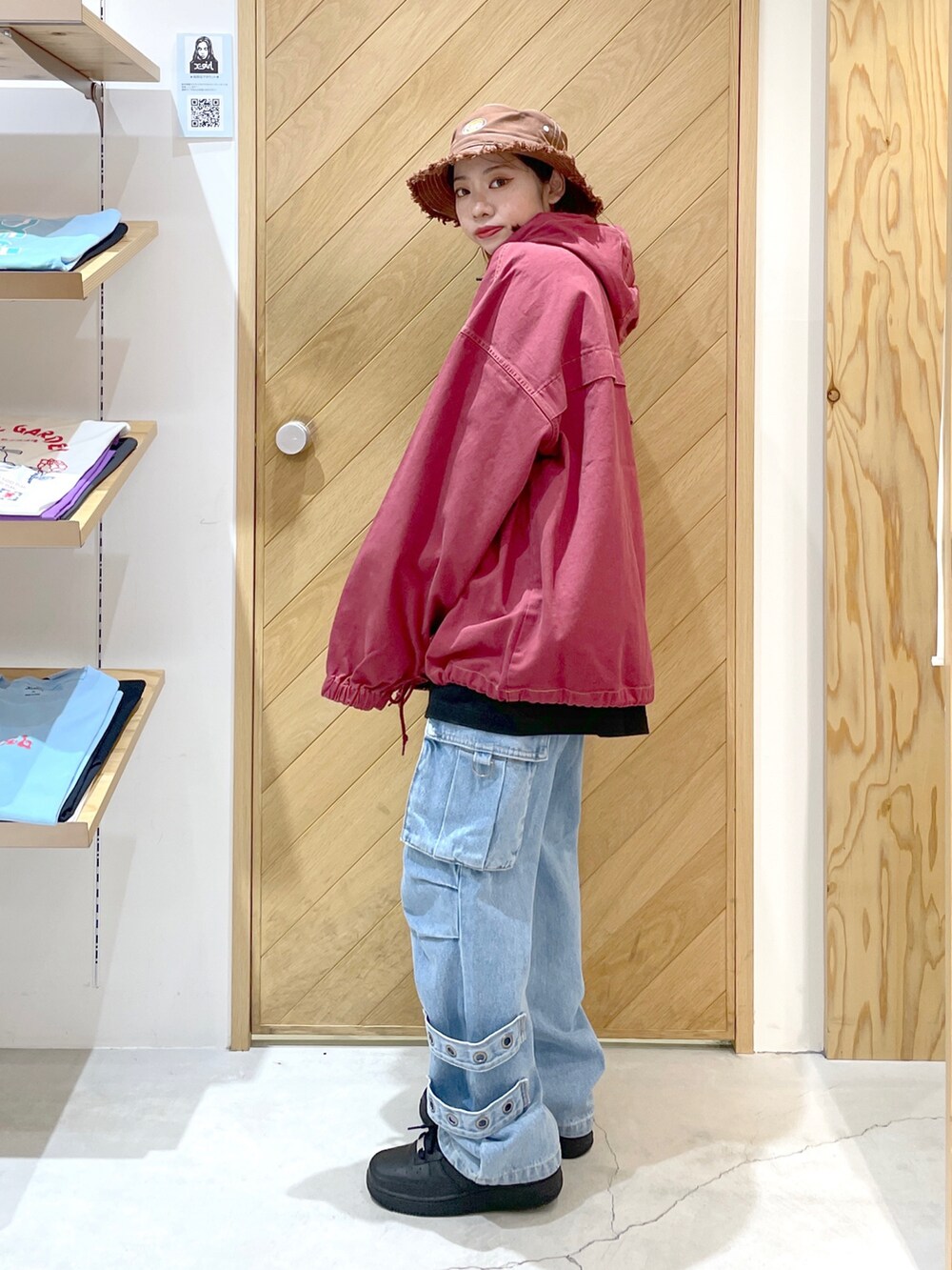 ブルー系のカーゴパンツ、レッド系のブルゾン、ブラック系のTシャツ/カットソーを着用したレディースの秋コーディネートの2枚目の写真