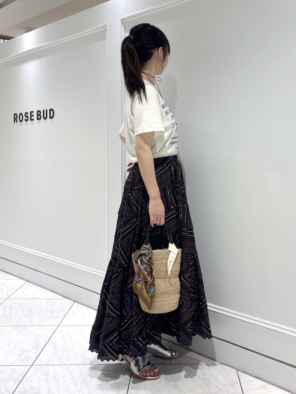 ベージュ系のトートバッグ、シルバー系のサンダル、ホワイト系のTシャツ/カットソーを着用したレディースの春コーディネートの2枚目の写真