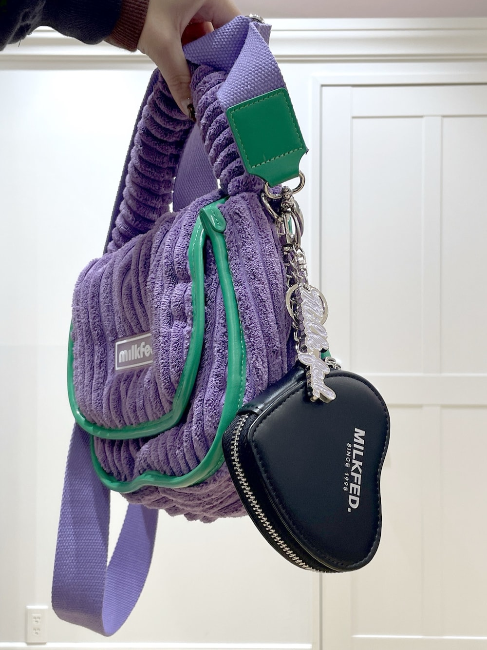 パープル系のショルダーバッグ、グレー系のパーカー、パープル系のTシャツ/カットソーを着用したレディースの秋コーディネートの5枚目の写真