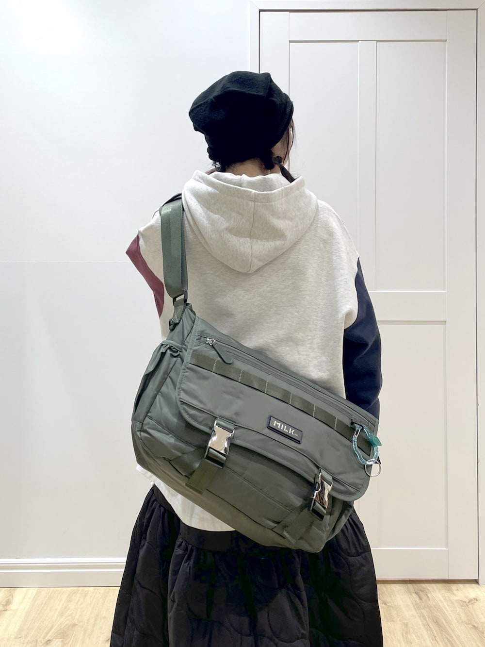 ブラック系のブーツ、グリーン系のメッセンジャーバッグ、ブラック系のスカートを着用したレディースの冬コーディネートの5枚目の写真