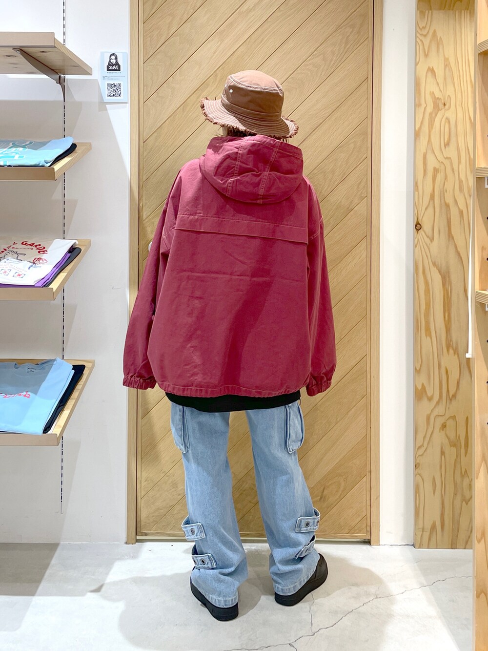 ブルー系のカーゴパンツ、レッド系のブルゾン、ブラック系のTシャツ/カットソーを着用したレディースの秋コーディネートの4枚目の写真