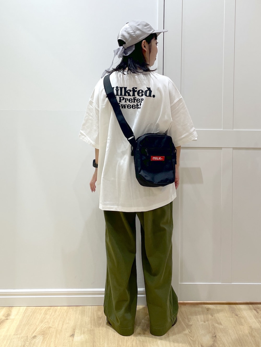 ブラック系のブーツ、グリーン系のその他パンツ、レッド系のショルダーバッグを着用したレディースの夏コーディネートの3枚目の写真