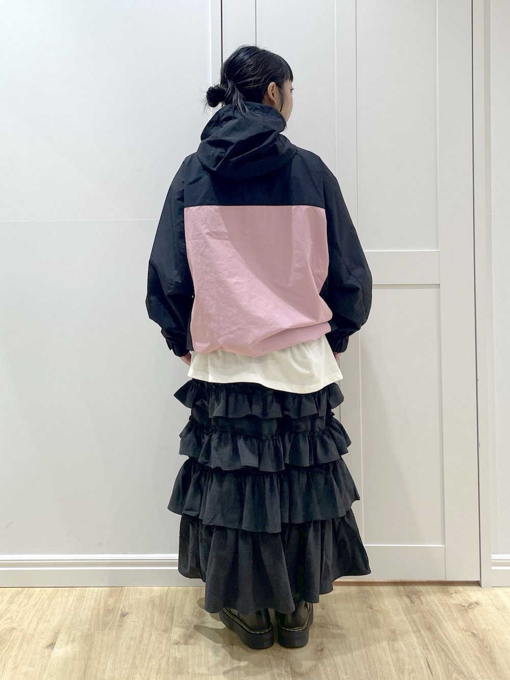 ブラック系のスカート、ホワイト系のTシャツ/カットソー、ピンク系のマウンテンパーカーを着用したレディースの秋コーディネートの3枚目の写真