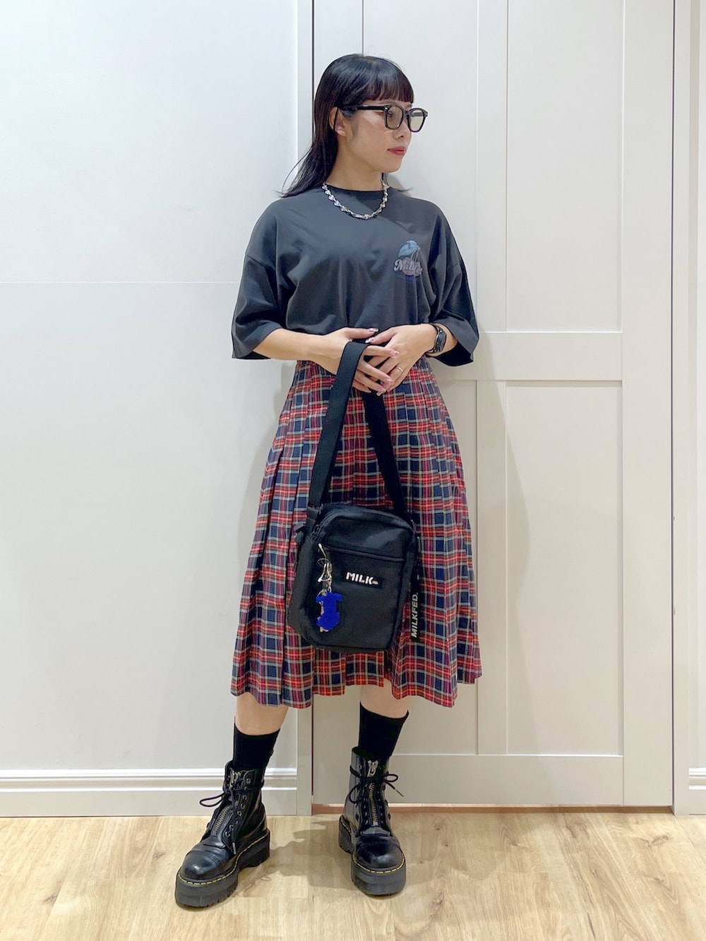 ブラック系のブーツ、ブルー系のスカート、グレー系のTシャツ/カットソーを着用したレディースの夏コーディネートの2枚目の写真