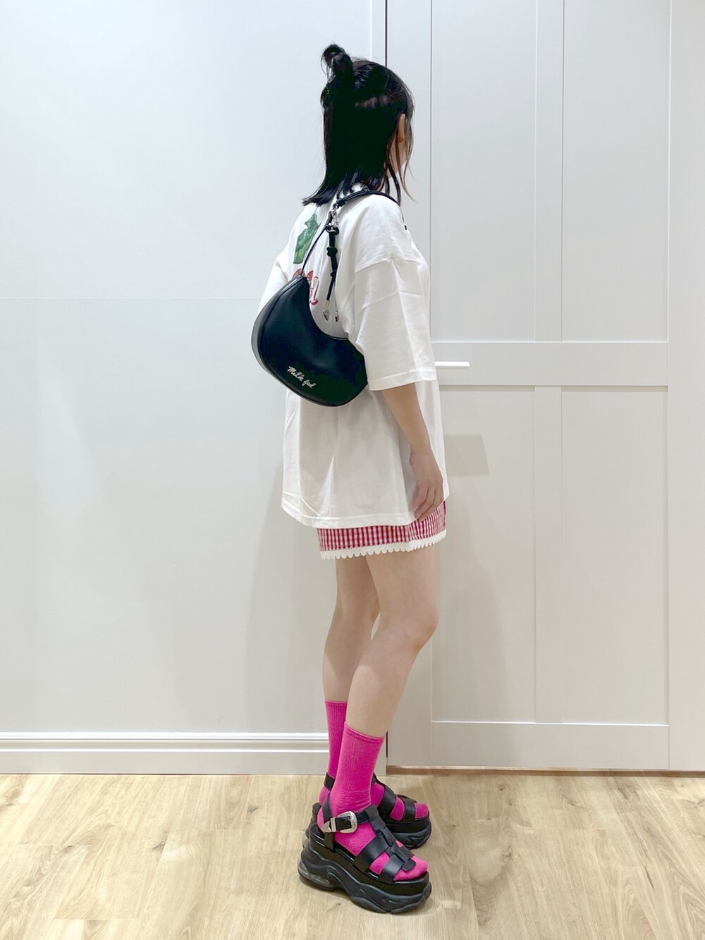 レッド系のその他パンツ、ブラック系のハンドバッグ、ホワイト系のTシャツ/カットソーを着用したレディースの春コーディネートの3枚目の写真