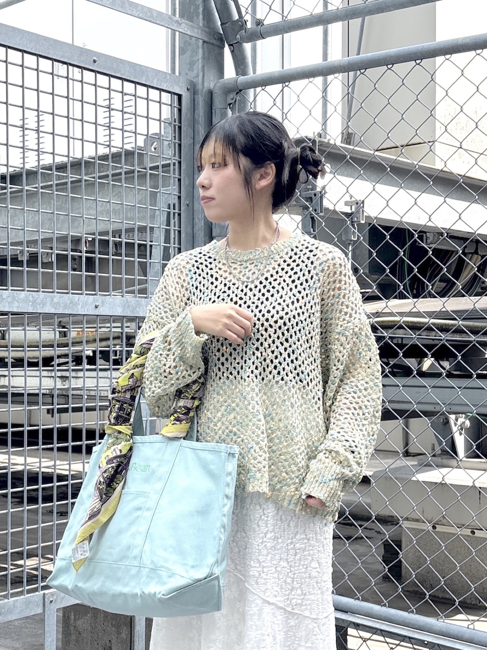 ブラック系のブーツ、ブルー系のニット/セーター、ホワイト系のスカートを着用したレディースの春コーディネートの5枚目の写真