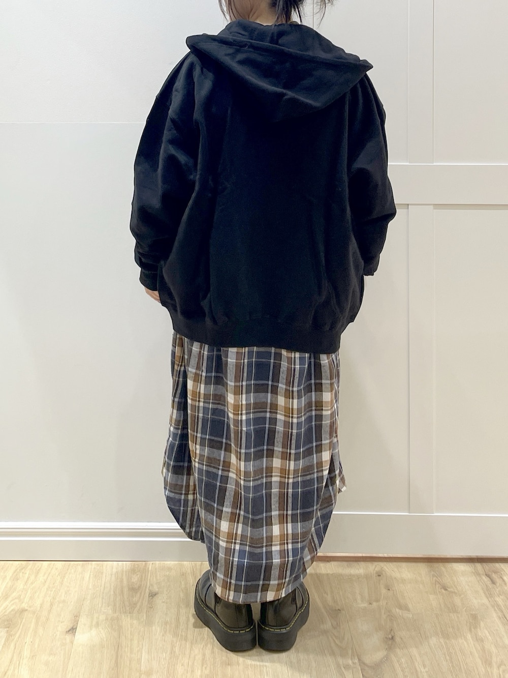 ブラウン系のベスト、イエロー系のワンピース、ブラック系のブーツを着用したレディースの冬コーディネートの7枚目の写真