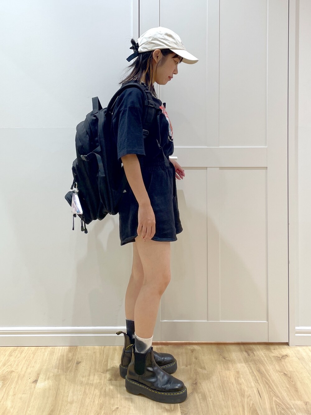 パープル系のバックパック/リュック、ブラック系のショルダーバッグ、ブラック系のブーツを着用したレディースの夏コーディネートの3枚目の写真