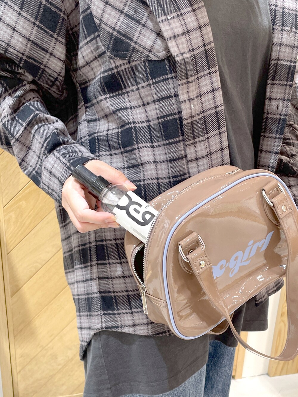 ベージュ系のボストンバッグ、ブルー系のデニムパンツ、ブラック系のスニーカーを着用したレディースの秋コーディネートの3枚目の写真