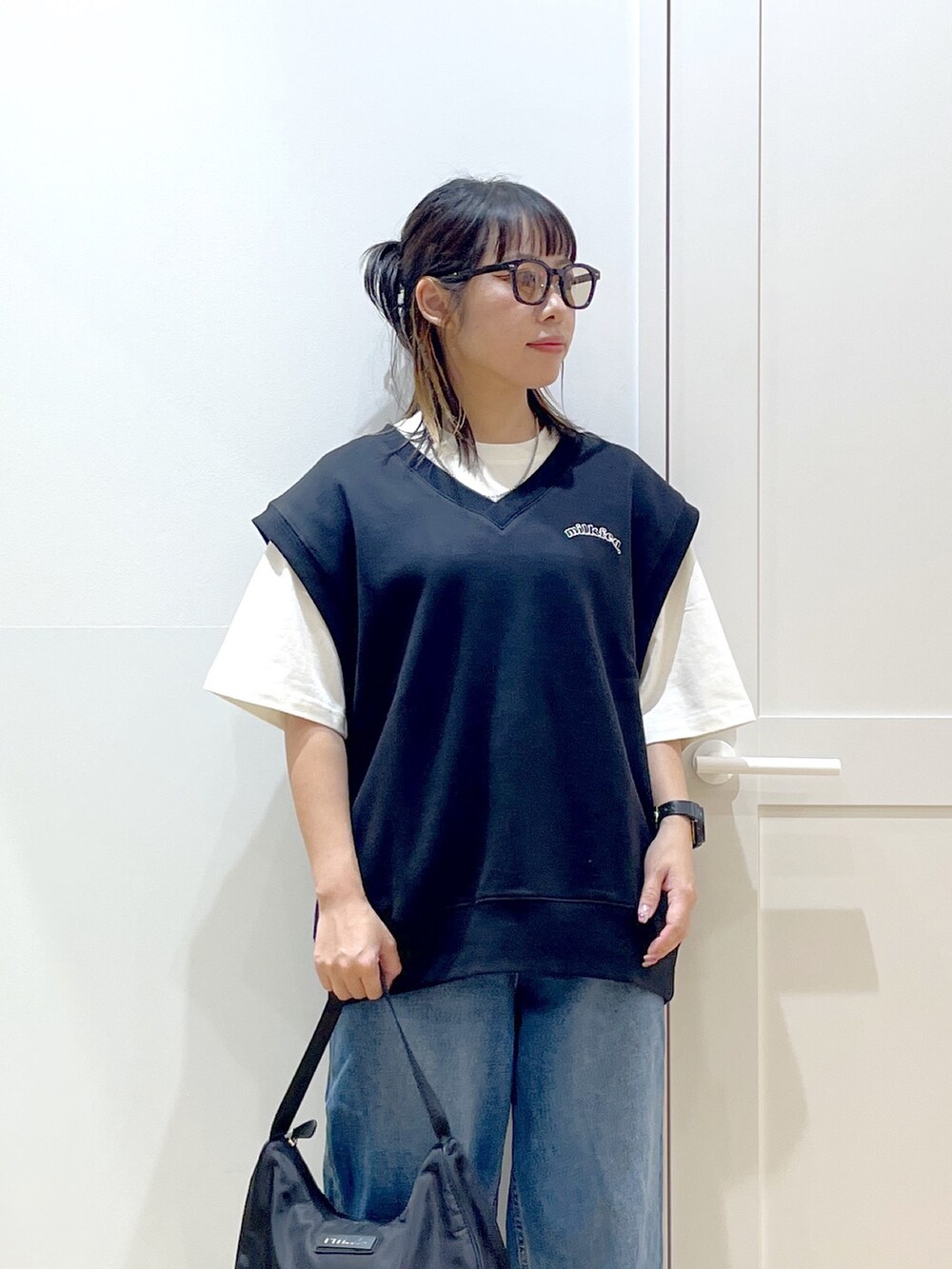 ブラック系のベスト、ブルー系のデニムパンツ、ホワイト系のTシャツ/カットソーを着用したレディースの夏コーディネートの5枚目の写真