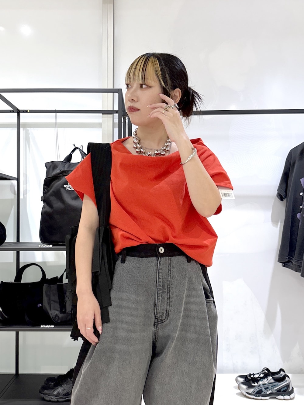 ブラック系のショルダーバッグ、ブラック系のその他シューズ、レッド系のTシャツ/カットソーを着用したレディースの春コーディネートの5枚目の写真