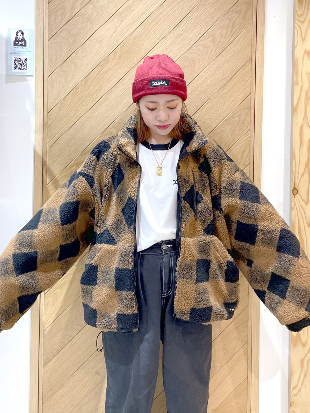 ブラウン系のブルゾン、ブラック系のデニムパンツ、ホワイト系のスニーカーを着用したレディースの秋コーディネートの3枚目の写真