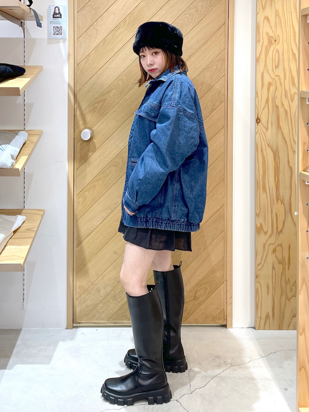 イエロー系のニット/セーター、ブルー系のデニムジャケット、ブラック系のブーツを着用したレディースの冬コーディネートの3枚目の写真