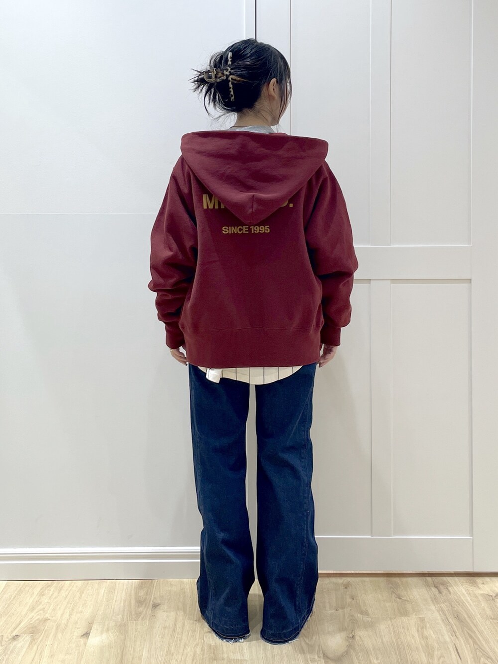 ベージュ系のブーツ、ブルー系のデニムパンツ、ブラック系のベストを着用したレディースの秋コーディネートの4枚目の写真