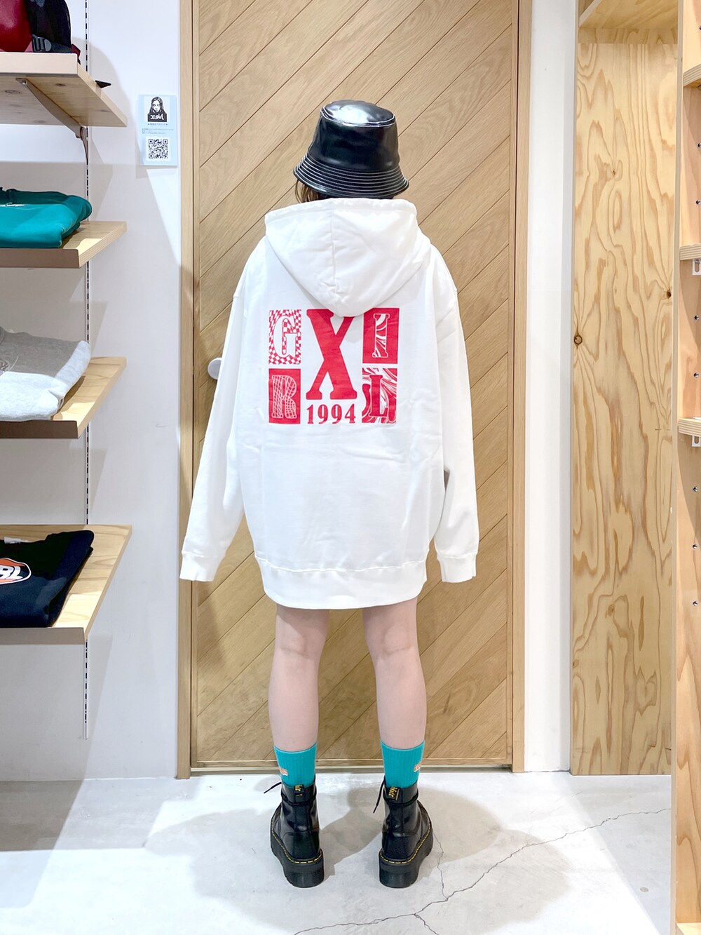 ホワイト系のパーカー、ブラック系のブーツ、ブラック系のハットを着用したレディースの秋コーディネートの3枚目の写真