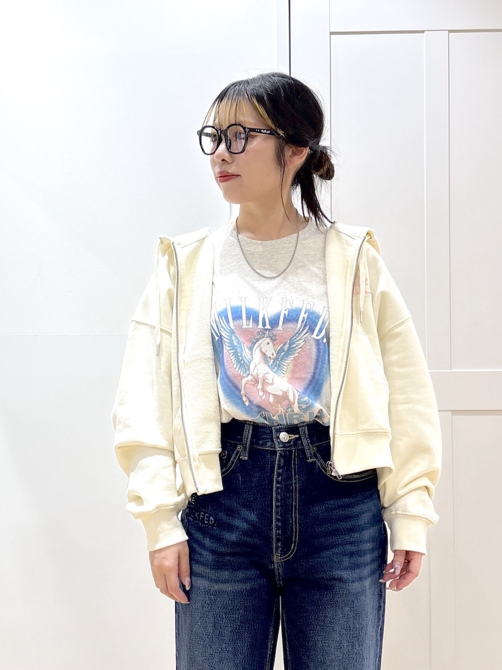 ブラック系のブーツ、ブルー系のデニムパンツ、ホワイト系のパーカーを着用したレディースの春コーディネートの5枚目の写真