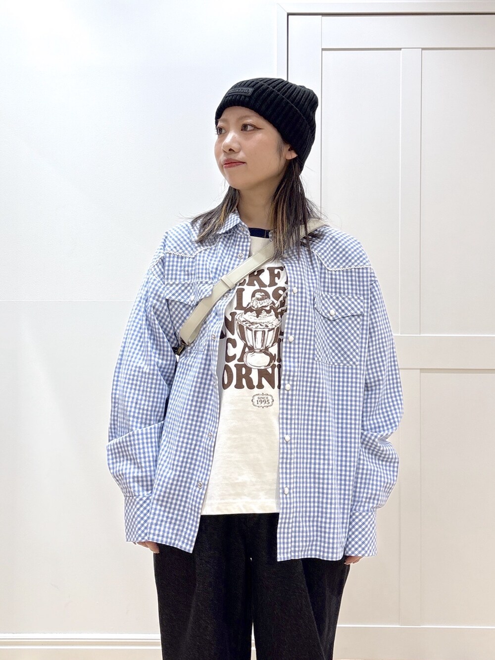 ブラック系のデニムパンツ、ホワイト系のTシャツ/カットソー、グレー系のショルダーバッグを着用したレディースの冬コーディネートの4枚目の写真