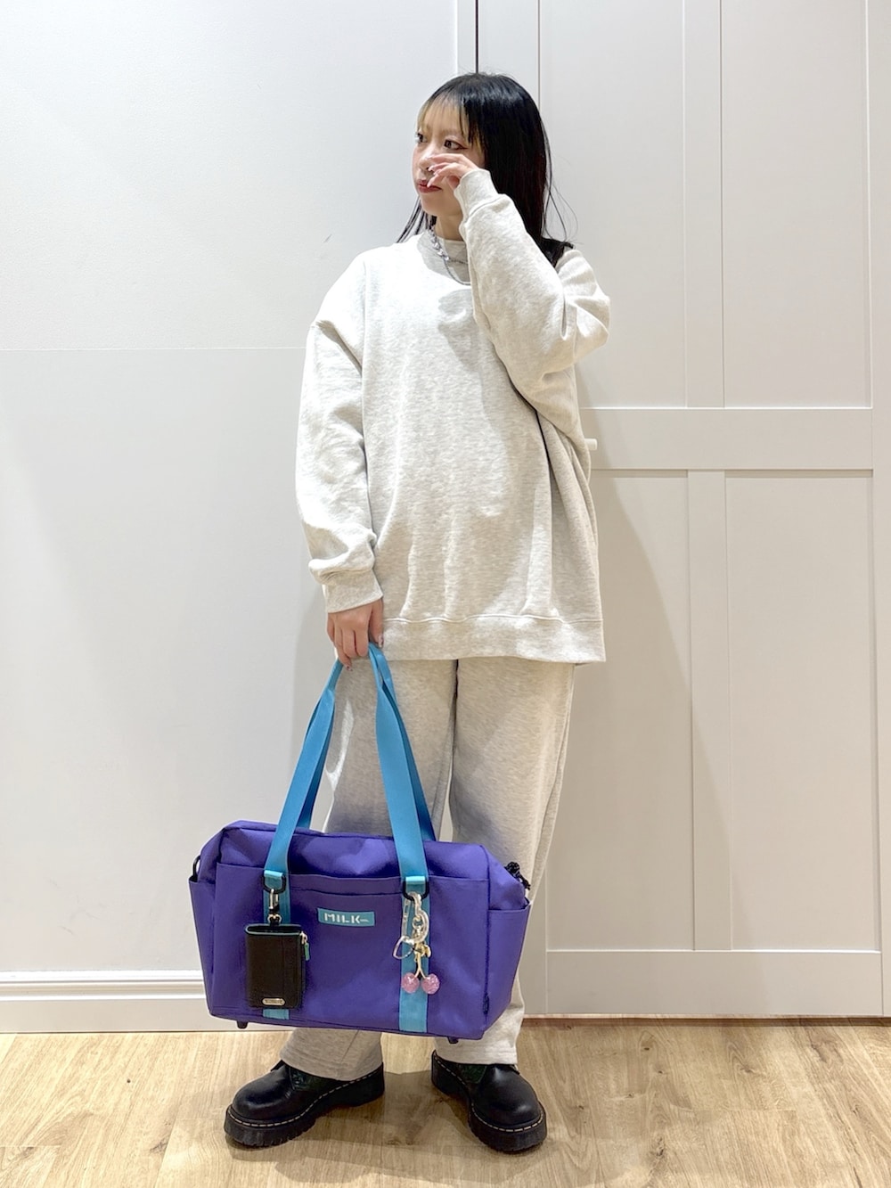 ベージュ系のスウェット、ベージュ系のスウェットパンツ、パープル系のショルダーバッグを着用したレディースの冬コーディネートの4枚目の写真