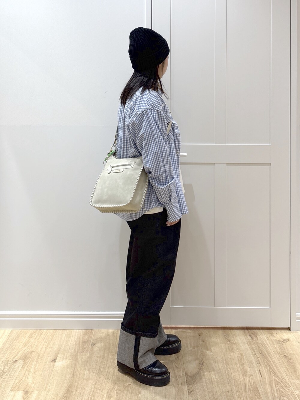 ブラック系のデニムパンツ、ホワイト系のTシャツ/カットソー、グレー系のショルダーバッグを着用したレディースの冬コーディネートの3枚目の写真