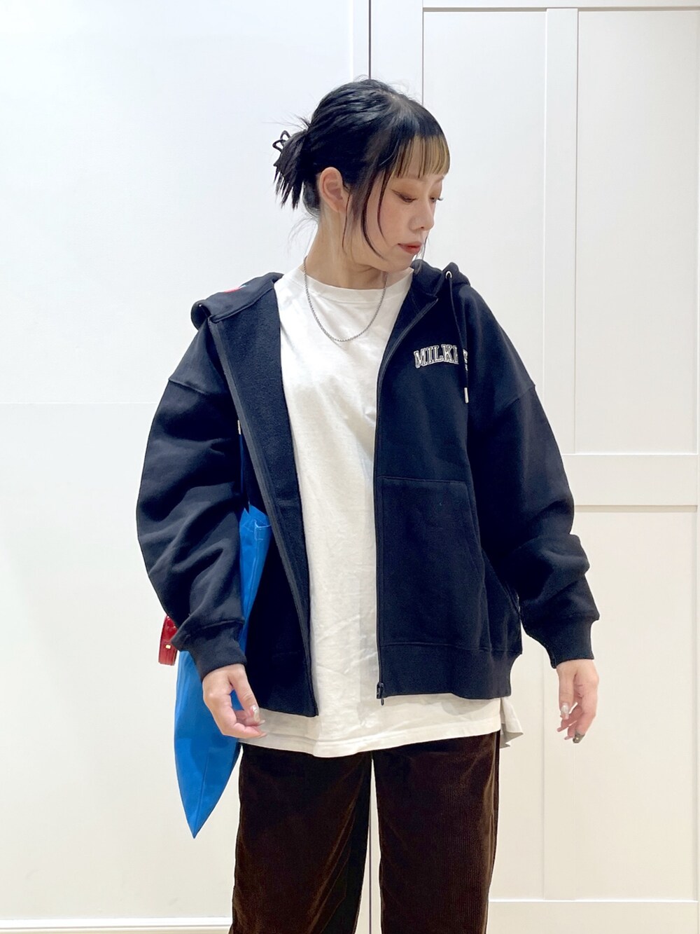 ブルー系のトートバッグ、ホワイト系のTシャツ/カットソー、ブラック系のパーカーを着用したレディースの冬コーディネートの5枚目の写真