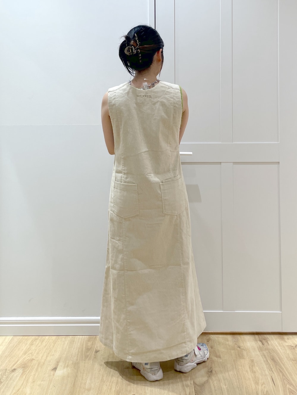 ベージュ系のワンピース、パープル系のニット/セーター、ホワイト系のショルダーバッグを着用したレディースの秋コーディネートの2枚目の写真