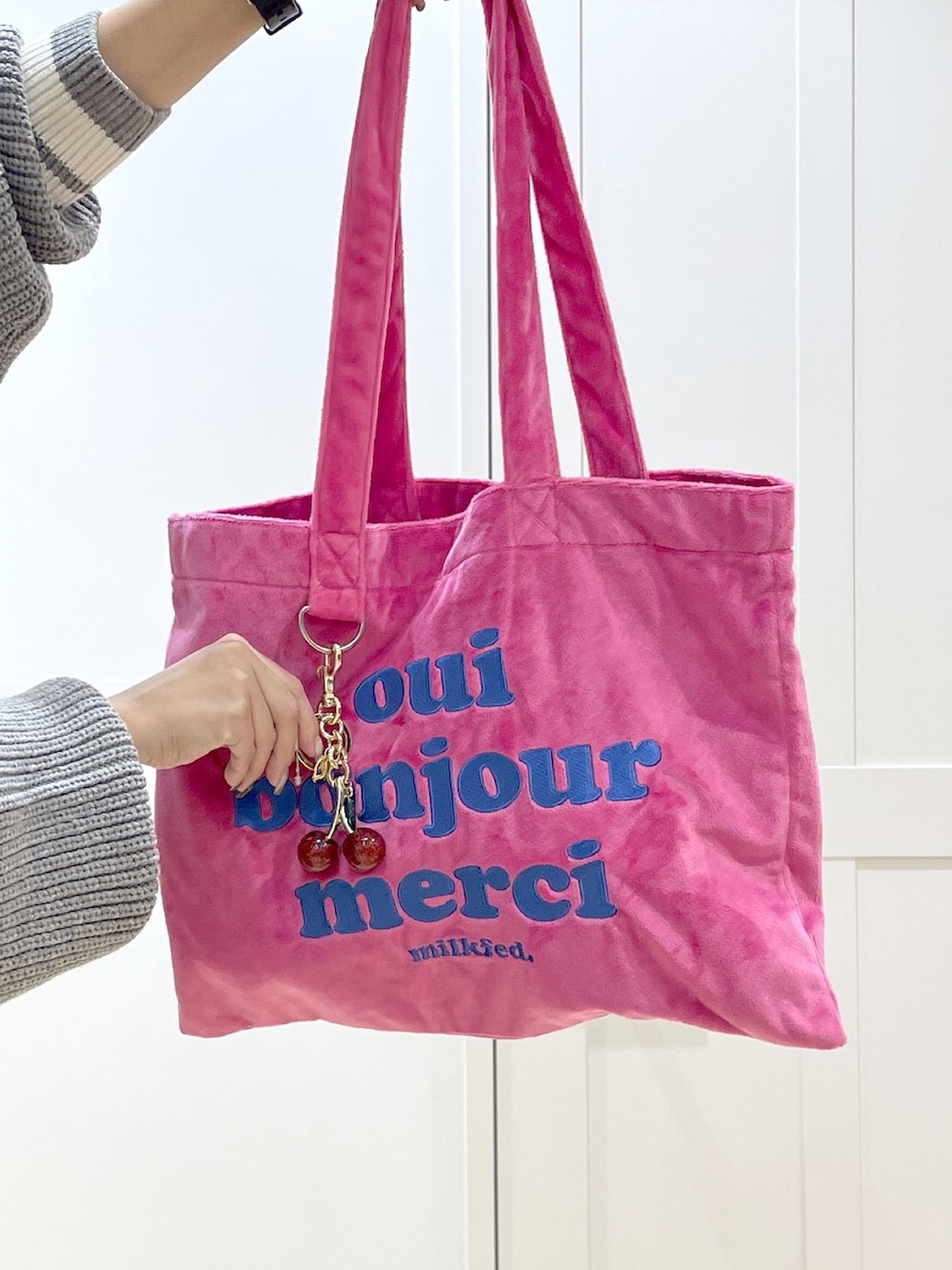 ホワイト系のスニーカー、ブラック系のデニムパンツ、グレー系のカーディガン/ボレロを着用したレディースの秋コーディネートの6枚目の写真