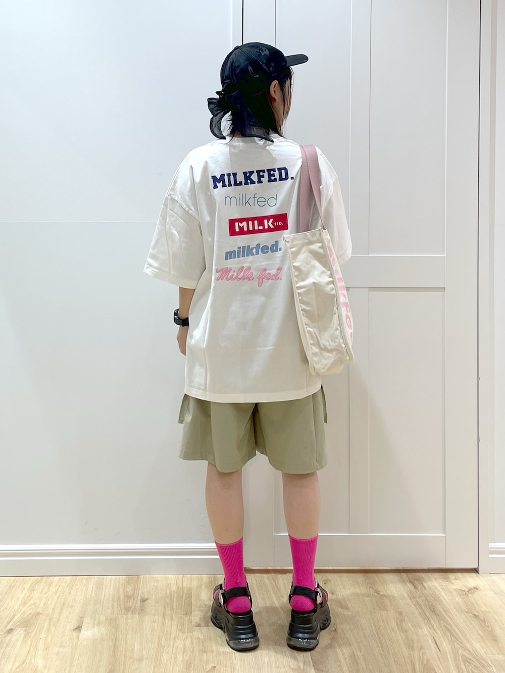 ホワイト系のTシャツ/カットソー、ブラック系のサンダル、ホワイト系のトートバッグを着用したレディースの夏コーディネートの2枚目の写真