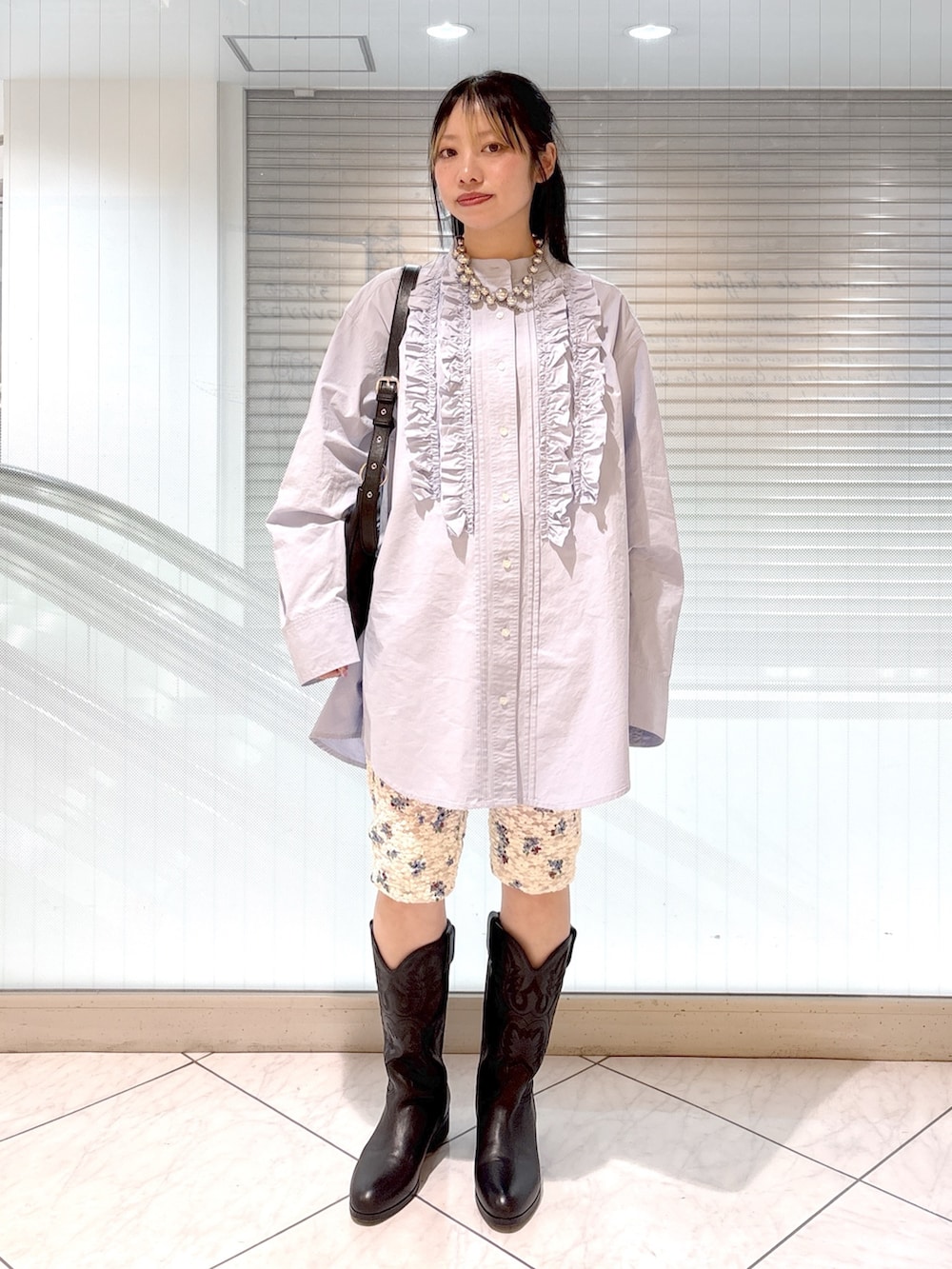 ブラック系のブーツ、ブルー系のシャツ/ブラウス、ベージュ系のテーラードジャケットを着用したレディースの春コーディネートの2枚目の写真