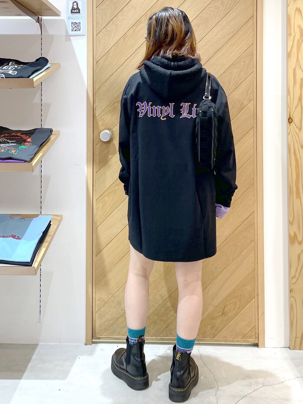 ブラック系のTシャツ/カットソー、ブラック系のブーツ、ブラック系のハンドバッグを着用したレディースの秋コーディネートの2枚目の写真