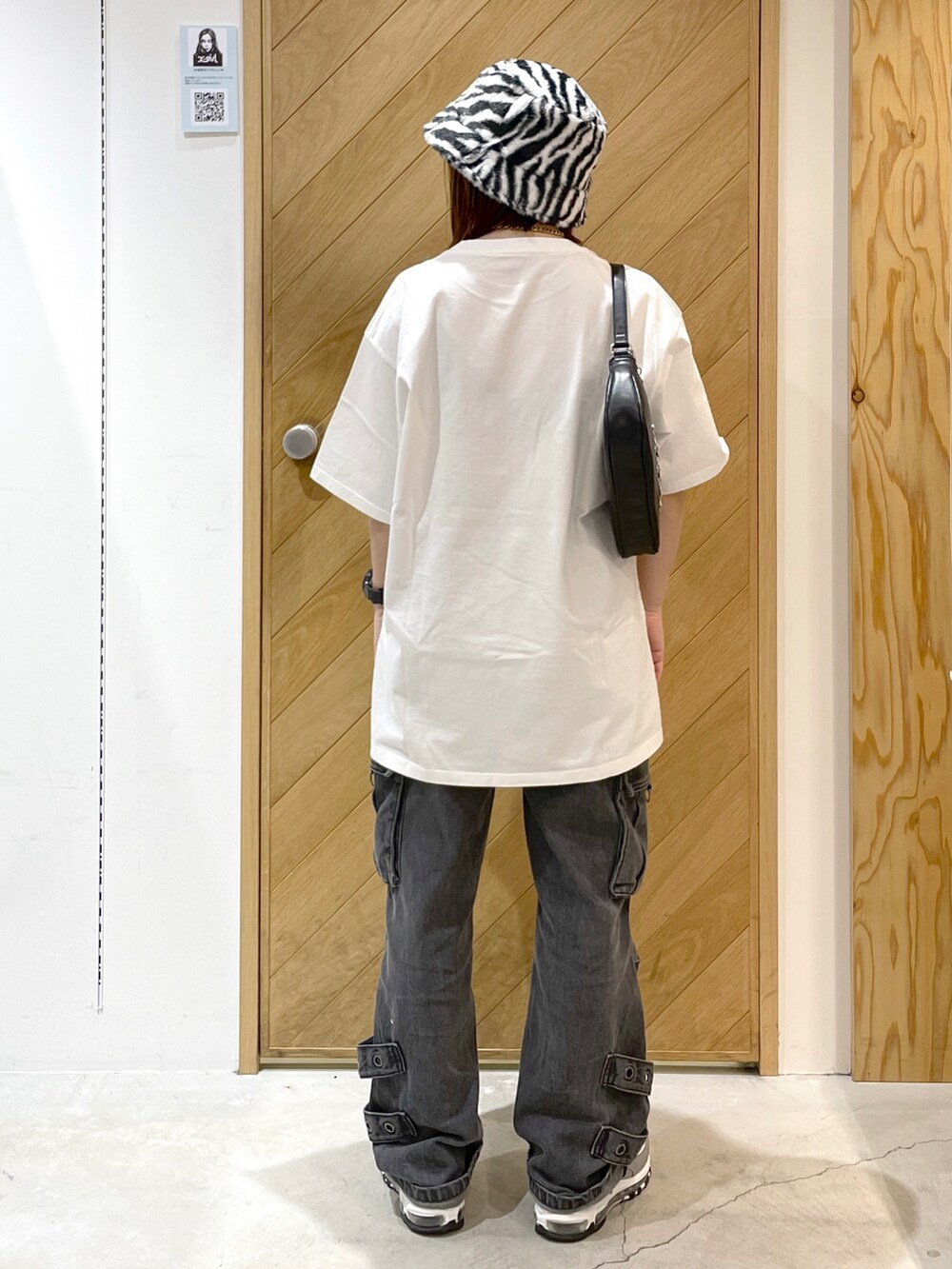 ブラック系のハンドバッグ、ホワイト系のTシャツ/カットソー、ブラック系のカーゴパンツを着用したレディースの冬コーディネートの3枚目の写真