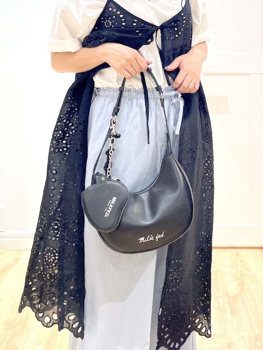 ブルー系のその他パンツ、ブラック系のブーツ、ブラック系のハンドバッグを着用したレディースの夏コーディネートの4枚目の写真