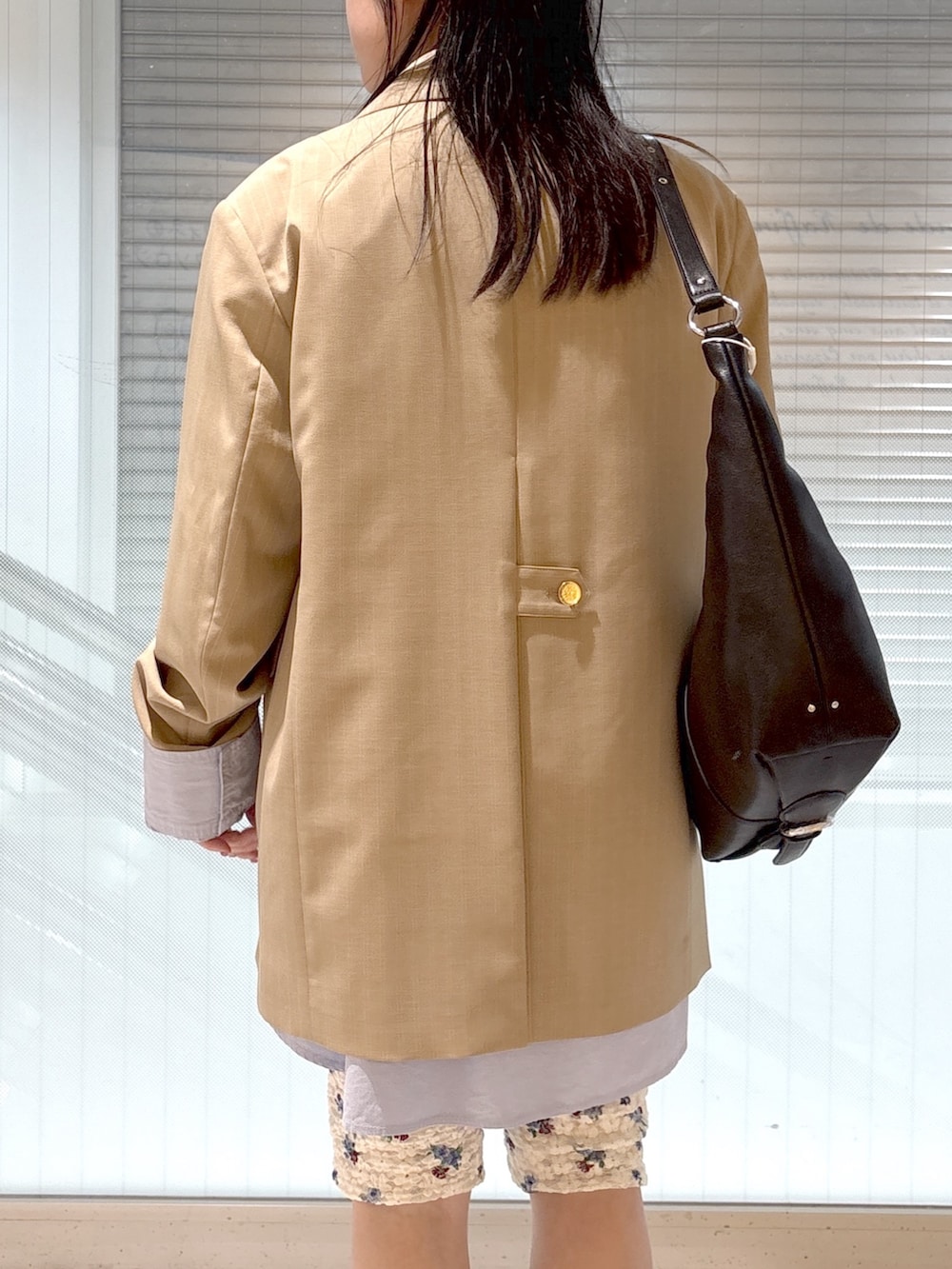 ブラック系のブーツ、ブルー系のシャツ/ブラウス、ベージュ系のテーラードジャケットを着用したレディースの春コーディネートの6枚目の写真