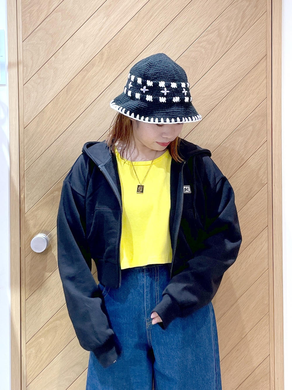 ブルー系のデニムパンツ、イエロー系のTシャツ/カットソー、ブラック系のパーカーを着用したレディースの秋コーディネートの3枚目の写真