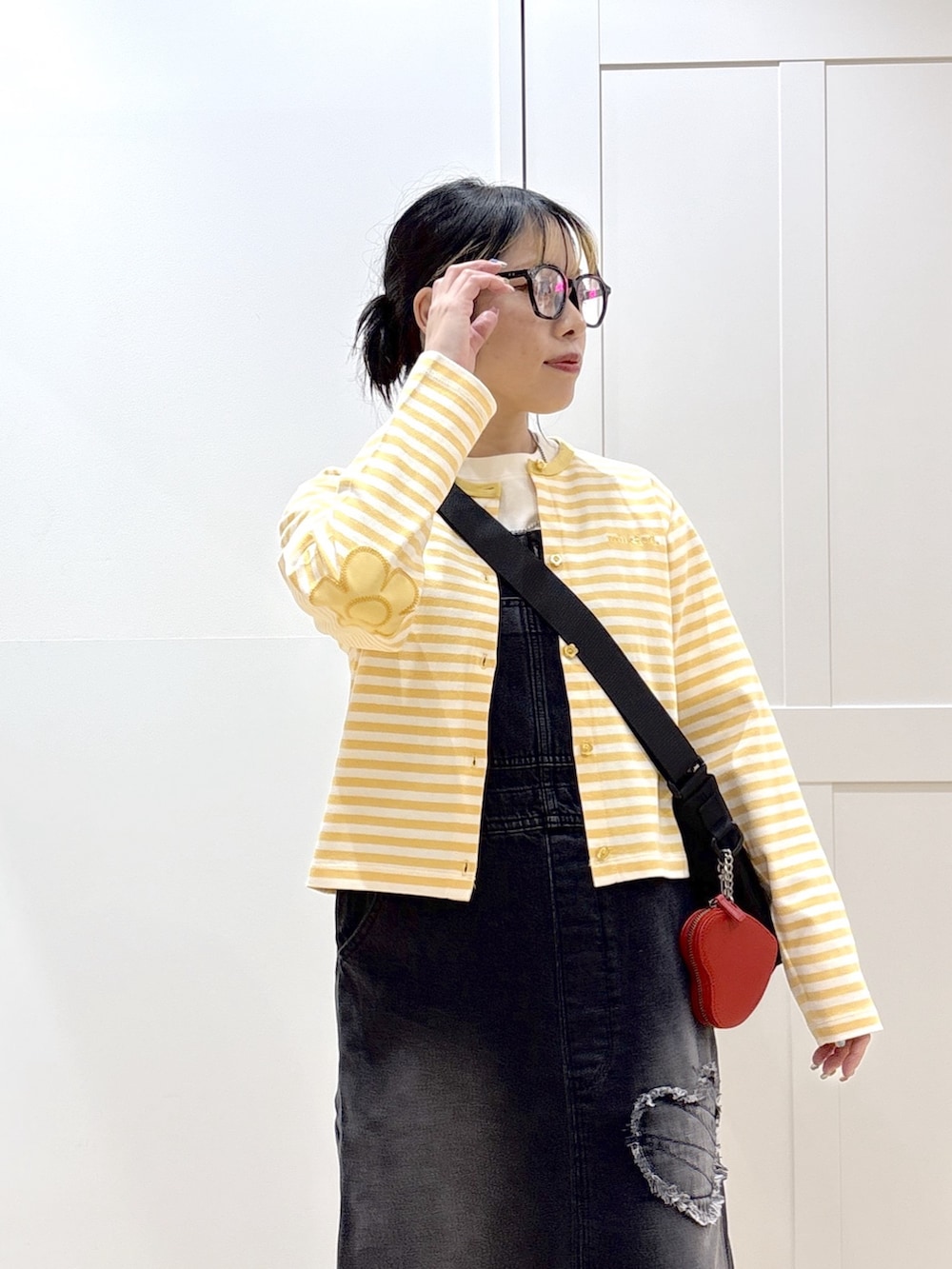 ブラック系のサロペット/オーバーオール、イエロー系のカーディガン/ボレロ、ホワイト系のTシャツ/カットソーを着用したレディースの春コーディネートの4枚目の写真