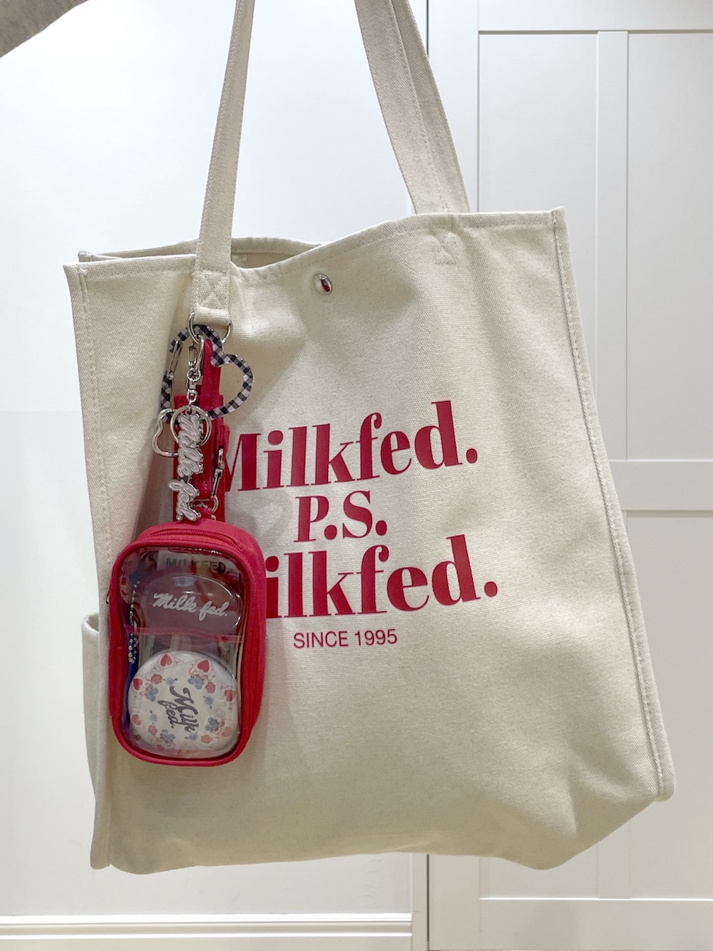 ブルー系のデニムスカート、ベージュ系のTシャツ/カットソー、レッド系のトートバッグを着用したレディースの冬コーディネートの6枚目の写真