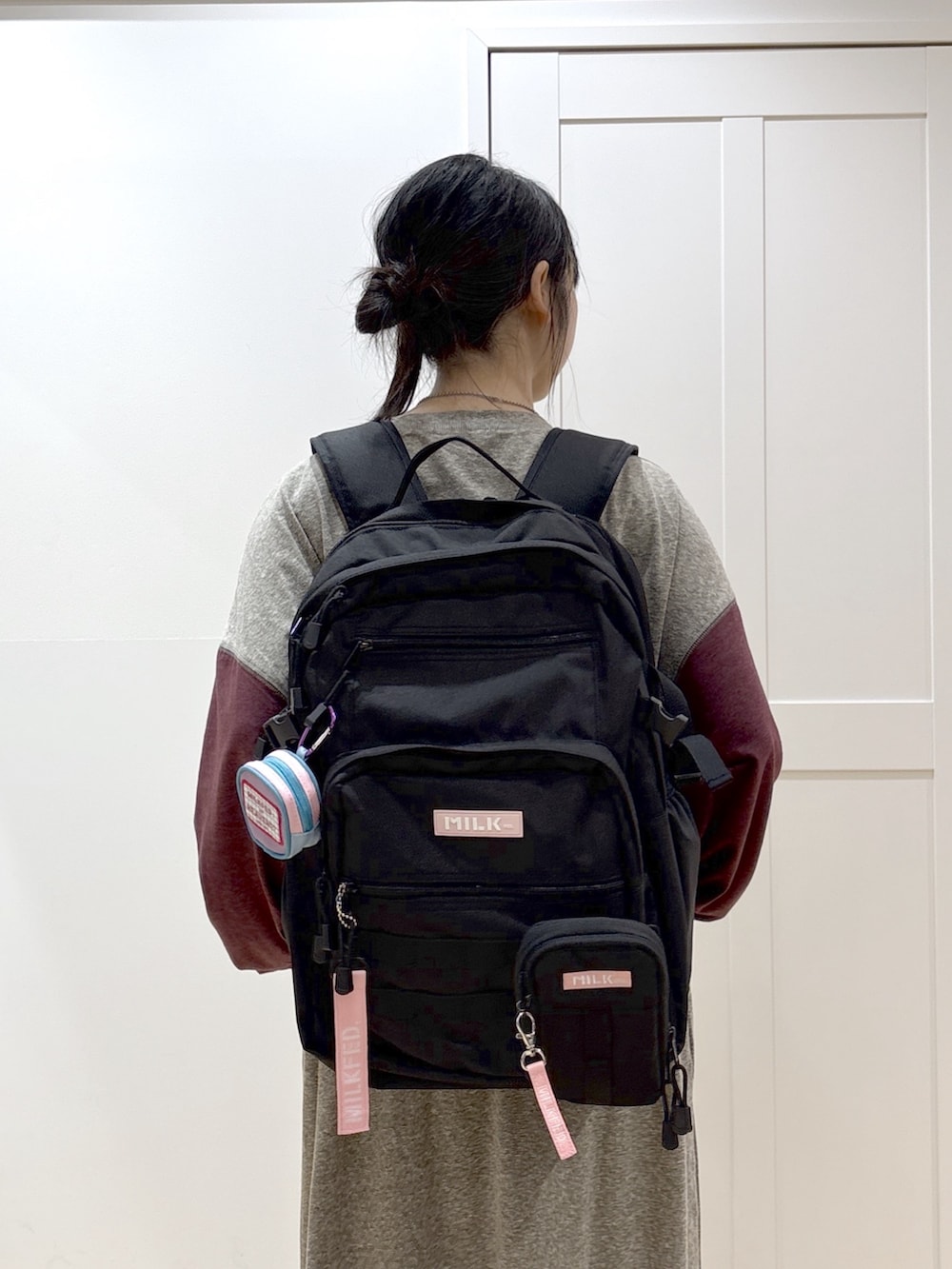 ピンク系のショルダーバッグ、ピンク系のバックパック/リュック、ブラック系のブーツを着用したレディースの春コーディネートの5枚目の写真