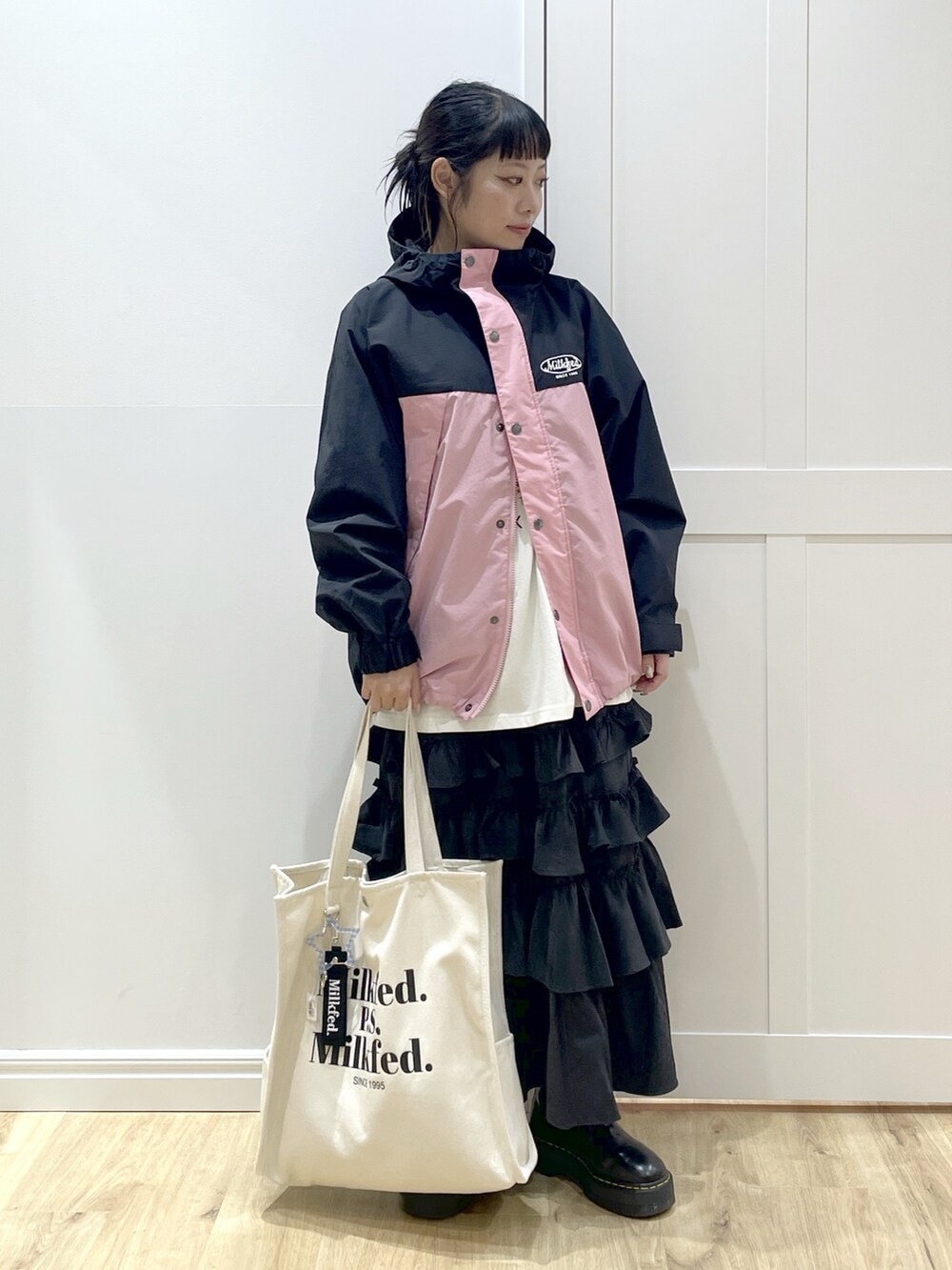 ブラック系のスカート、ホワイト系のTシャツ/カットソー、ピンク系のマウンテンパーカーを着用したレディースの秋コーディネートの2枚目の写真