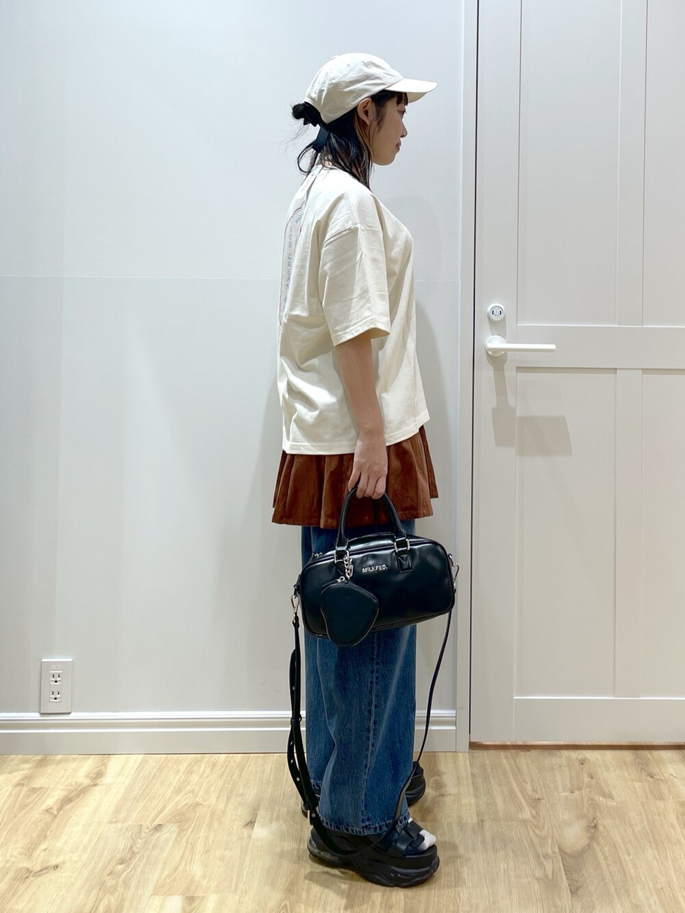 ブルー系のデニムパンツ、ブラウン系のその他パンツ、ホワイト系のTシャツ/カットソーを着用したレディースの夏コーディネートの2枚目の写真