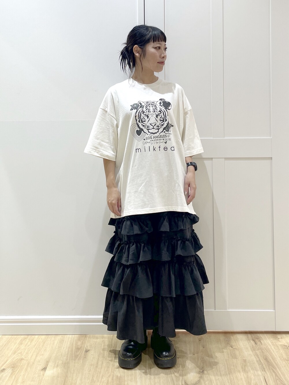 ブラック系のスカート、ホワイト系のTシャツ/カットソー、ピンク系のマウンテンパーカーを着用したレディースの秋コーディネートの6枚目の写真