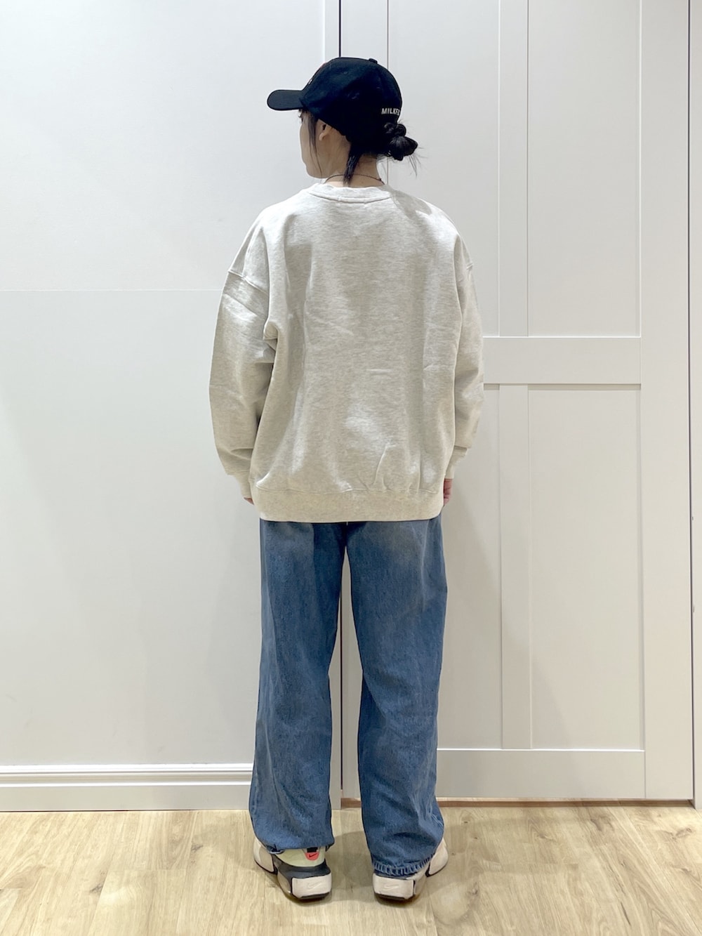 ブルー系のデニムパンツ、ベージュ系のスウェット、レッド系のショルダーバッグを着用したレディースの冬コーディネートの7枚目の写真