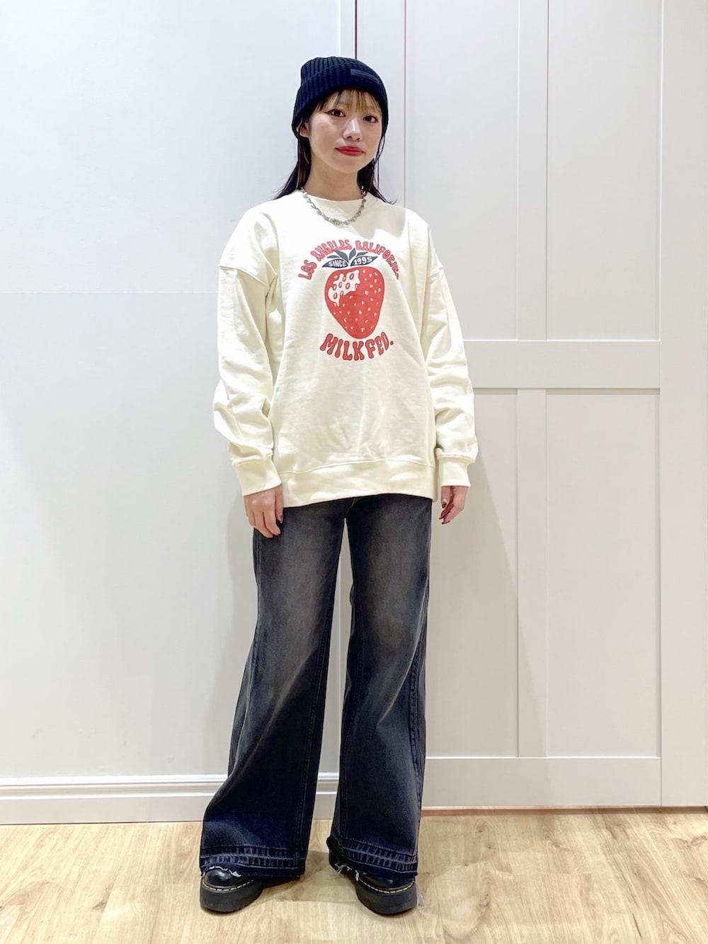 ブラック系のデニムパンツ、レッド系のワンピース、ホワイト系のスウェットを着用したレディースの秋コーディネートの5枚目の写真