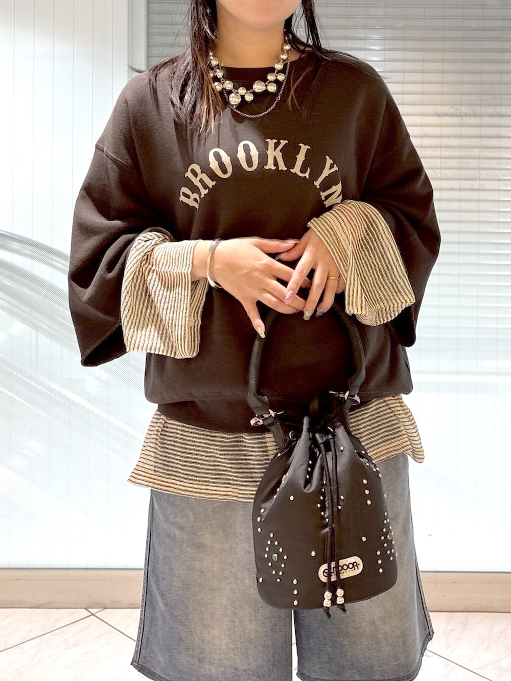 ブラック系のブーツ、ブラック系のショルダーバッグ、ブルー系のその他パンツを着用したレディースの春コーディネートの5枚目の写真