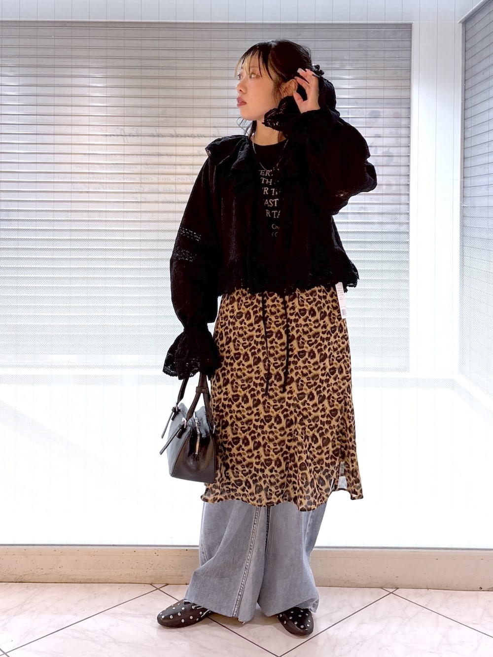 ブラック系のその他シューズ、ブルー系のデニムパンツ、ベージュ系のスカートを着用したレディースの春コーディネートの4枚目の写真