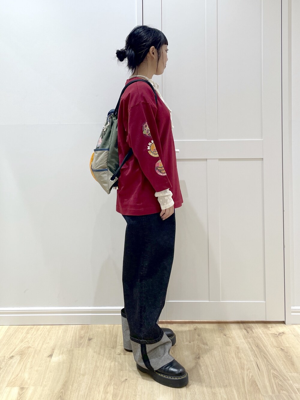 ブルー系のデニムパンツ、レッド系のTシャツ/カットソー、ホワイト系のTシャツ/カットソーを着用したレディースの秋コーディネートの3枚目の写真