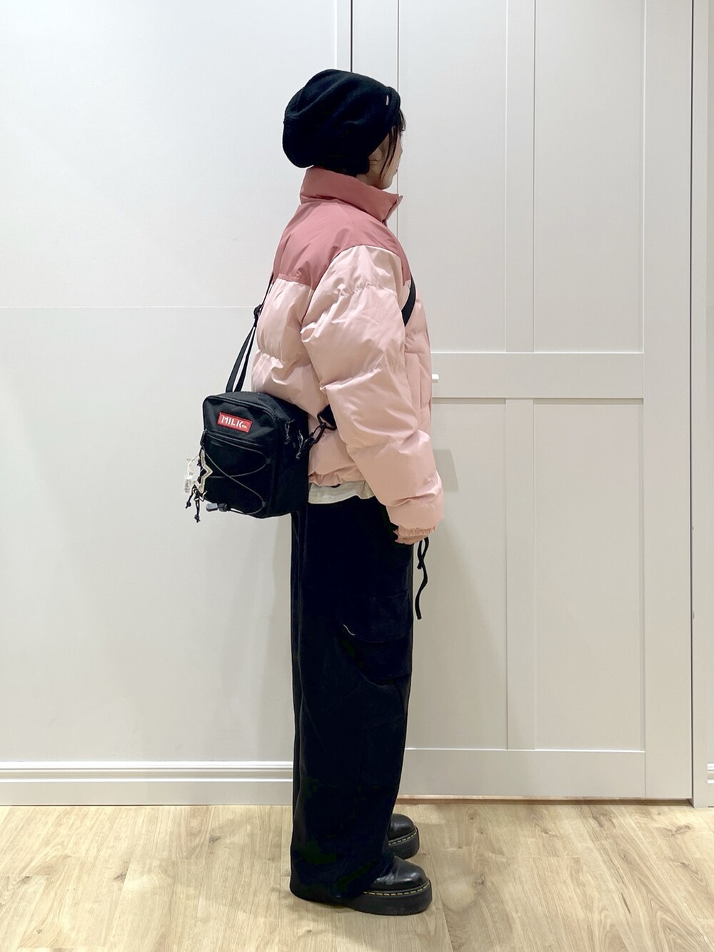 ブラック系のスウェットパンツ、ピンク系のダウンジャケット/コート、ベージュ系のTシャツ/カットソーを着用したレディースの冬コーディネートの3枚目の写真